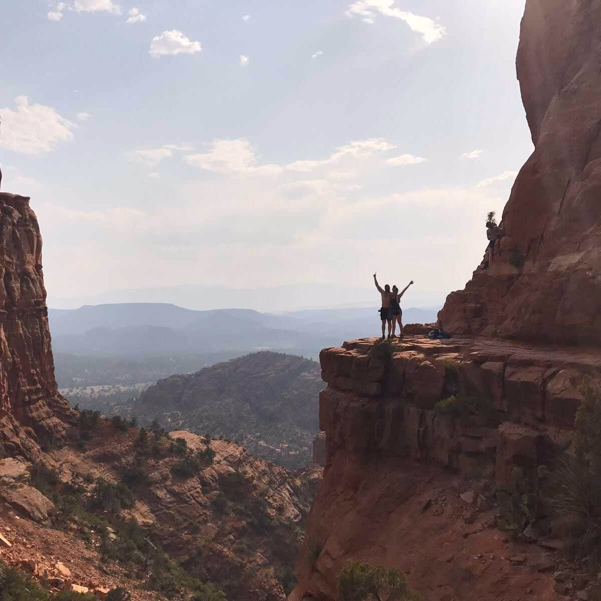 hikers posing on ledge in red rock canyon